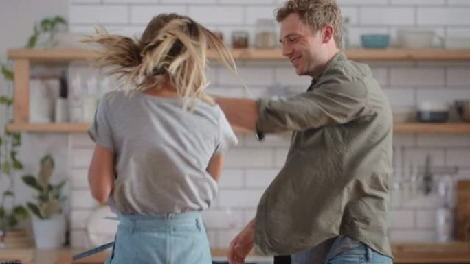 跳舞的情侣庆祝在厨房跳舞有趣，享受家里有趣的浪漫关系4k镜头