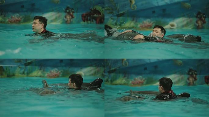 亚洲男子与海豚一起游泳