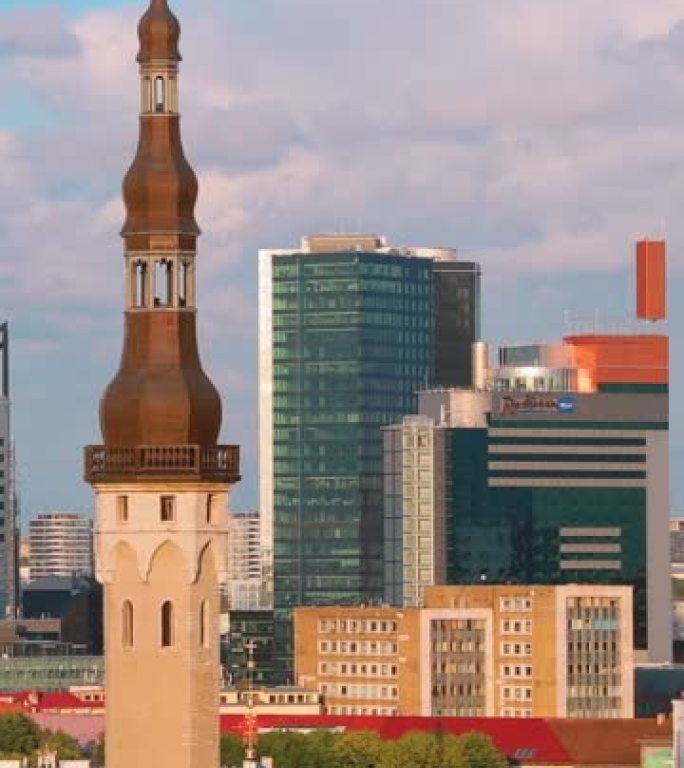 爱沙尼亚塔林-2019年7月1日: 市政厅塔以现代城市摩天大楼为背景。垂直镜头视频城市中心建筑。缩小