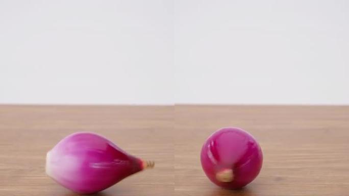 垂直视频，木桌背景上红洋葱旋转的慢动作，特写