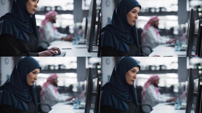 中东软件开发人员在技术公司办公室的计算机上工作的肖像。年轻的穆斯林妇女为创新的互联网和软件作为服务项