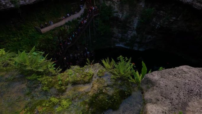 墨西哥巴利亚多利德的Cenote Saamal视图。人们在cenote休息和游泳。