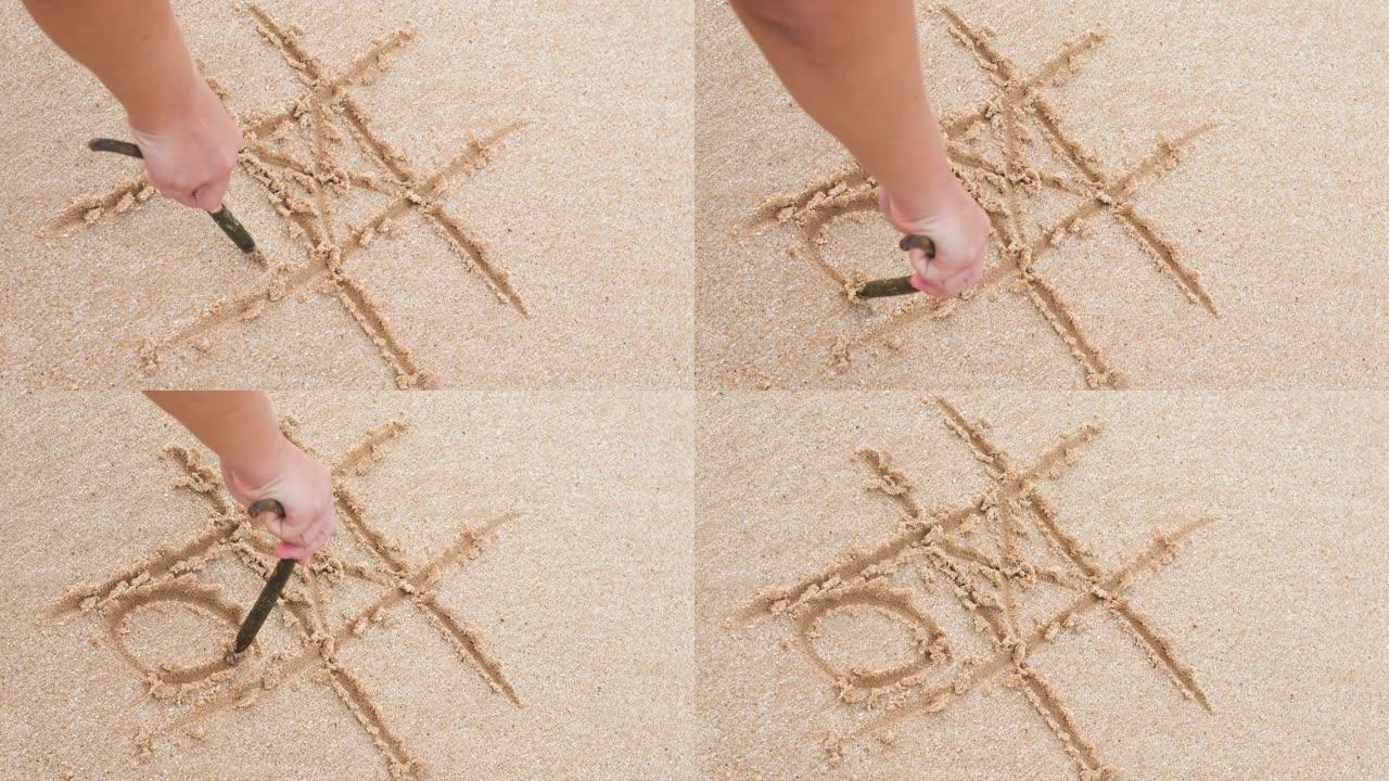 女孩在沙滩上手绘井字。