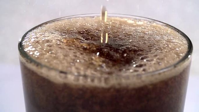 可乐碳酸饮料倒入玻璃飞溅。慢动作