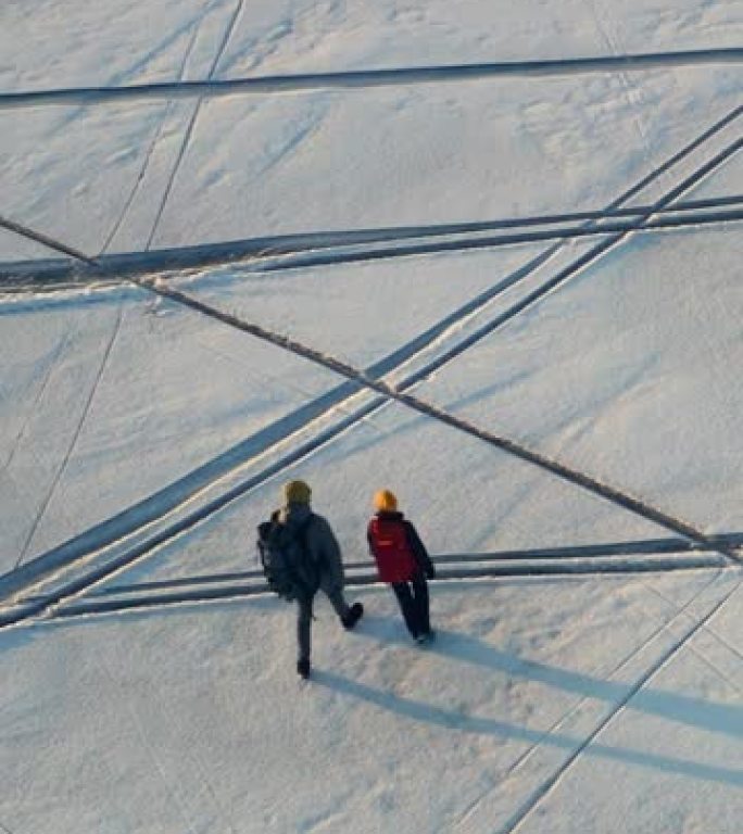 两名穿越雪场的旅行者的鸟瞰图