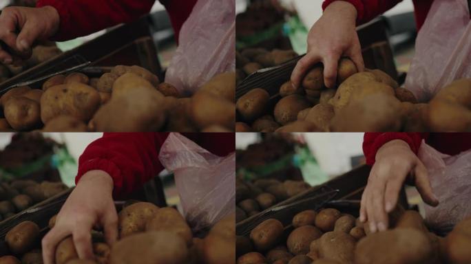 一个在市场上选择原始农场有机土豆的人