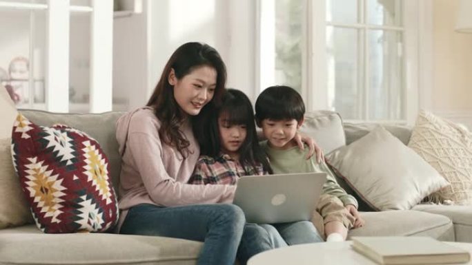 亚洲母亲和孩子在家里一起使用笔记本电脑