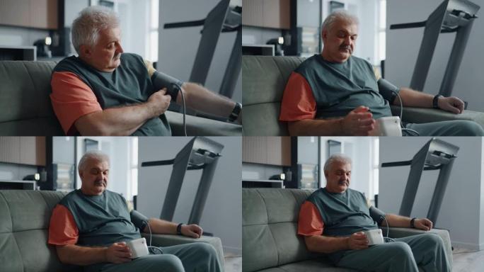 老人坐在家里的沙发上，用血压计测量血压