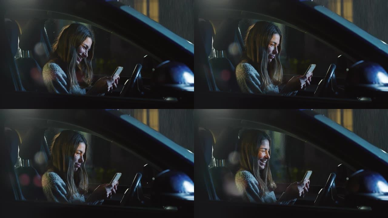 一个年轻女子在雨夜坐在车里，使用智能手机的肖像。女司机玩得开心，一边聊天一边微笑，在社交媒体上与朋友