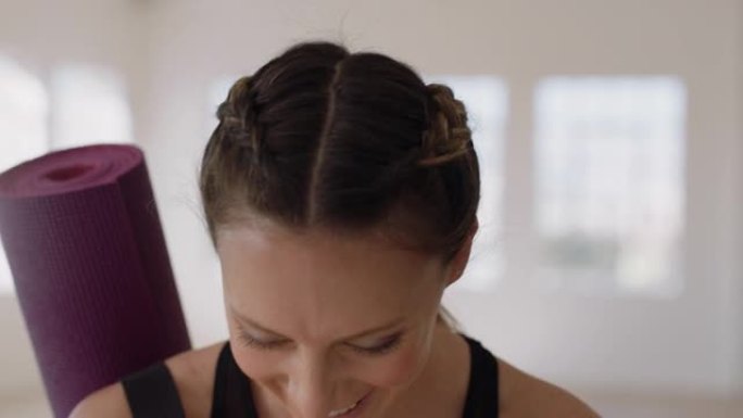 肖像美丽的白人妇女笑着享受瑜伽课，在健身室练习健康的生活方式