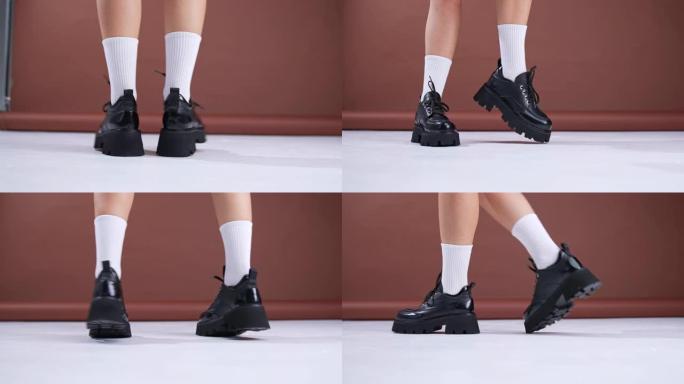 大型拖拉机鞋底上的黑色皮革秋鞋。穿着白色袜子的模特展示了她在镜头前跳舞的现代时尚鞋类。特写。