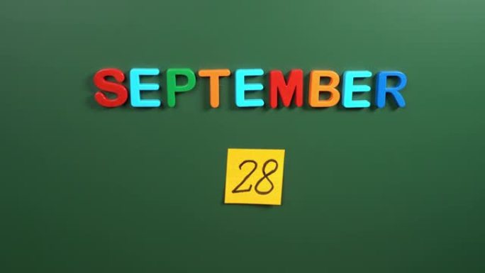 9月28日日历日用手在学校董事会上贴一张贴纸。28 9月日期。9月第二十八天。第28个日期号。28天