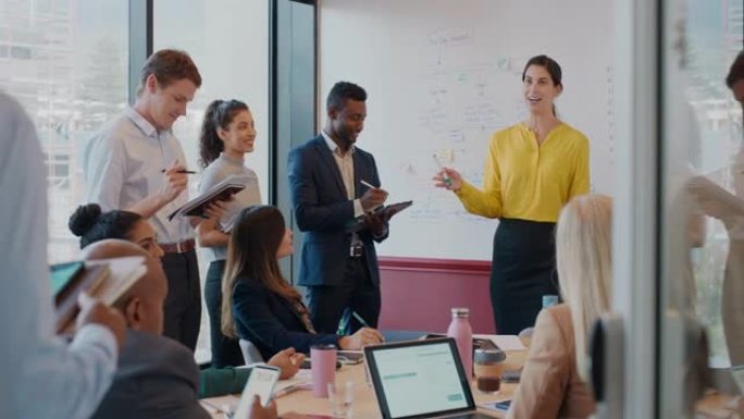 女商人在办公室会议上在白板上展示想法，与公司团队项目经理在会议室演讲中与同事讨论战略