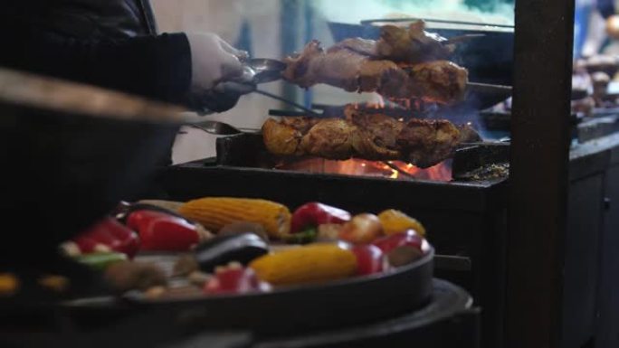 关闭烹饪街头食物。多汁的烤肉串和在烤架上用煤油炸的蔬菜。野餐或晚上烧烤。冬季交易会，户外贸易。