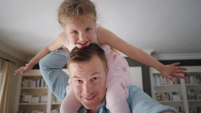 快乐的父亲肩上扛着小女孩爸爸抱着女儿在家享受俏皮游戏视频聊天概念4k