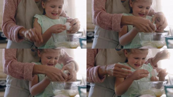 可爱的小女孩帮助妈妈在厨房里烘烤混合配料把鸡蛋打碎成碗里，在家和妈妈一起准备食谱