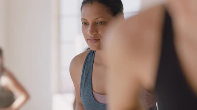 瑜伽课肖像年轻怀孕混血女子练习姿势抱着肚子享受健身工作室的集体锻炼