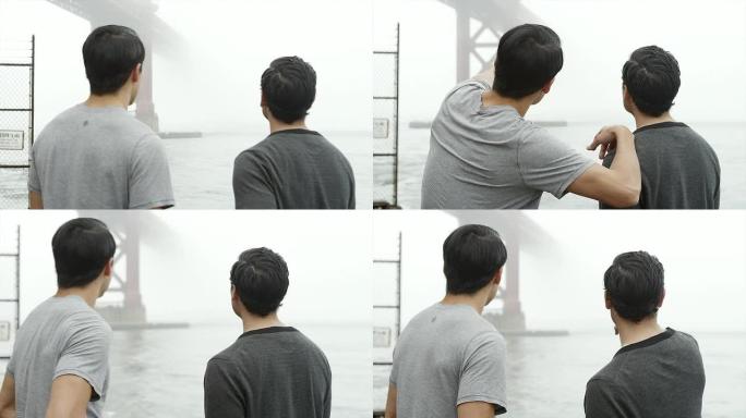两个朋友站在雾天看金门大桥