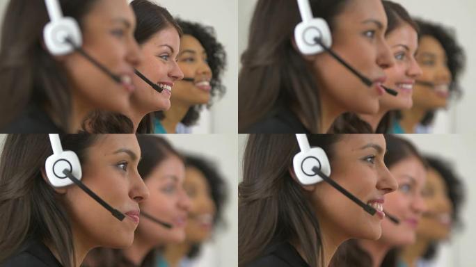 三个客户服务代表在耳机上交谈之间的机架焦点