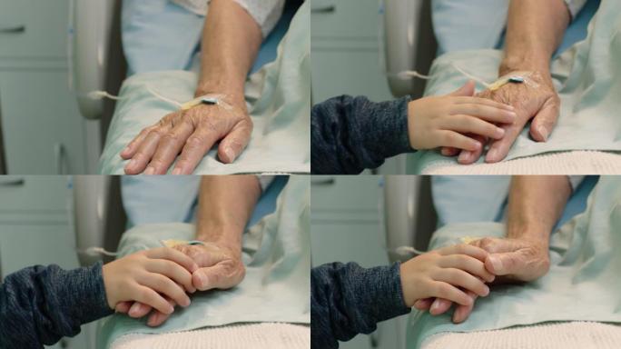 小男孩抱着祖母的手奶奶躺在医院的病床上，孩子在床边对从疾病中康复的祖父母表示爱意。医疗保健家庭支持