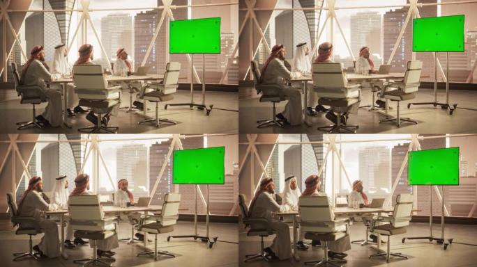 中东高管和管理层与一个远程国际办公室进行会议视频电话。商人在电视上观看带有绿屏模拟显示的演示文稿。