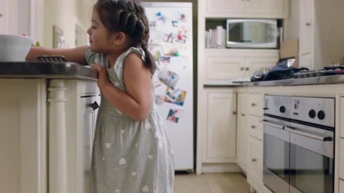 快乐的小女孩拿饼干偷偷摸摸的孩子在家里的厨房偷饼干