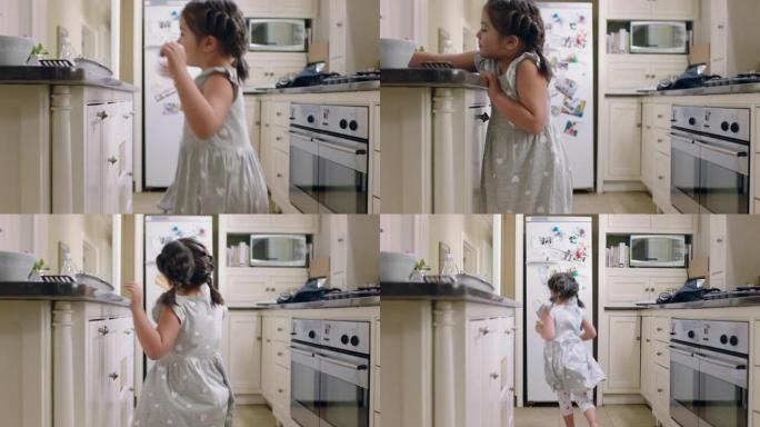 快乐的小女孩拿饼干偷偷摸摸的孩子在家里的厨房偷饼干