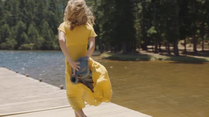 年轻女子在码头上奔跑，准备跳进湖中享受夏天的自由