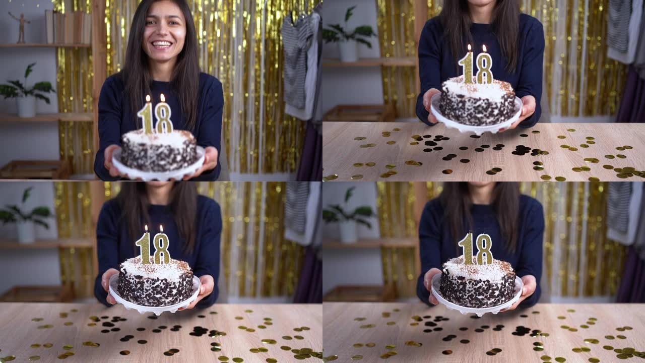 假期和庆祝概念。兴奋的女人庆祝18岁生日，在蛋糕上吹18号蜡烛，戴着派对蛋糕，在相机上玩得开心。观点
