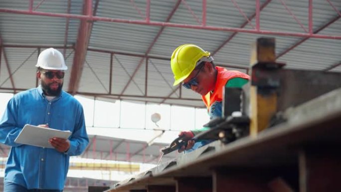年轻的亚洲工人使用机器焊铁，手工作，主管在工业工厂检查，焊工或劳动焊接钢，经理检查，行业概念。