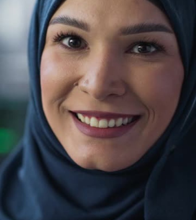 垂直屏幕: 中东女性使用计算机的肖像，看着相机并微笑。授权穆斯林信息技术专家，软件工程师，开发人员或