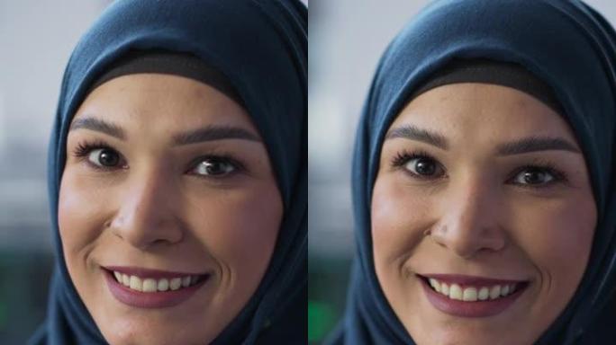 垂直屏幕: 中东女性使用计算机的肖像，看着相机并微笑。授权穆斯林信息技术专家，软件工程师，开发人员或
