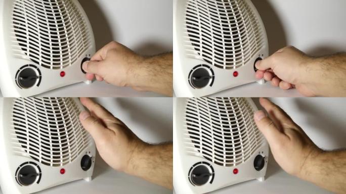 该人打开风扇加热器以加热房间。便携式、自主、电动空间供暖。