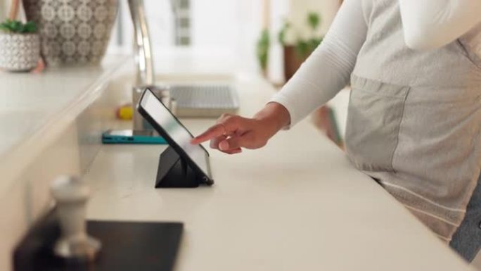 平板电脑、订单和在咖啡店工作的女服务员在无线接口上提供服务或付款。咖啡馆、厨房和销售人员，一名员工在