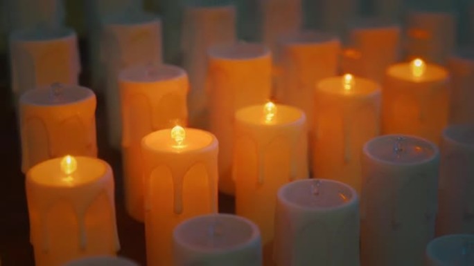 现代天主教教堂里的电蜡烛。人造火的金色辉光特写。