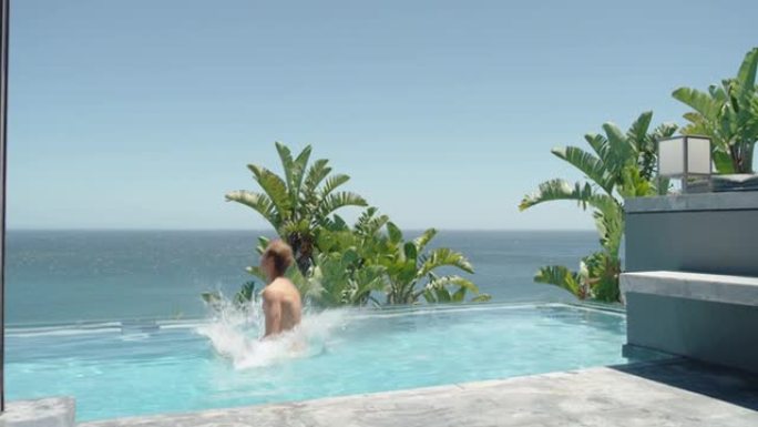 年轻人跳进豪华酒店的游泳池玩得开心暑假在温暖阳光明媚的日子里享受热带度假胜地游泳地中海旅游4k