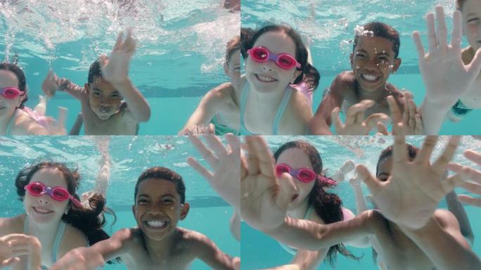 快乐的孩子在游泳池水下游泳微笑挥舞的手孩子们享受游泳一起漂浮在水晶般清澈的水中暑假