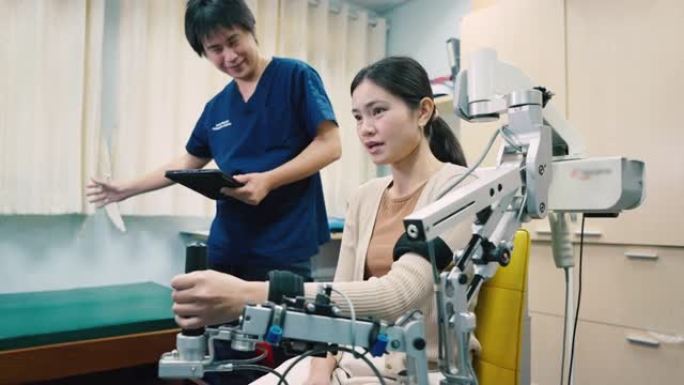 理疗师用机械臂照顾一名手臂虚弱的女性患者手臂虚弱康复。