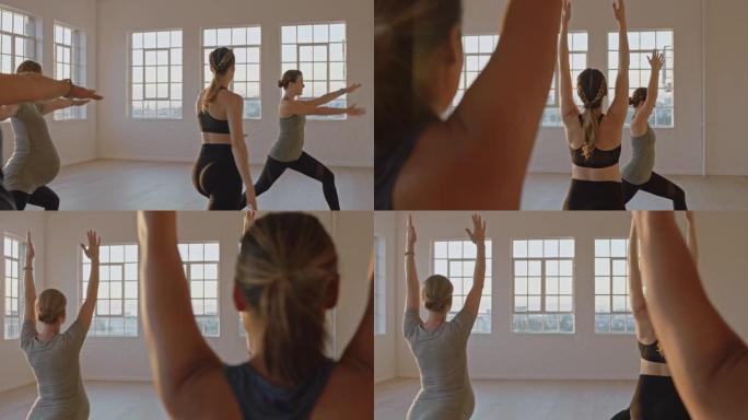 日出时在工作室与教练一起练习战士姿势的健康孕妇瑜伽课享受团体体能锻炼
