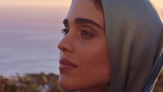 美丽的穆斯林妇女的特写肖像，看起来沉思，探索灵性，感觉和平，享受日落，戴着头巾