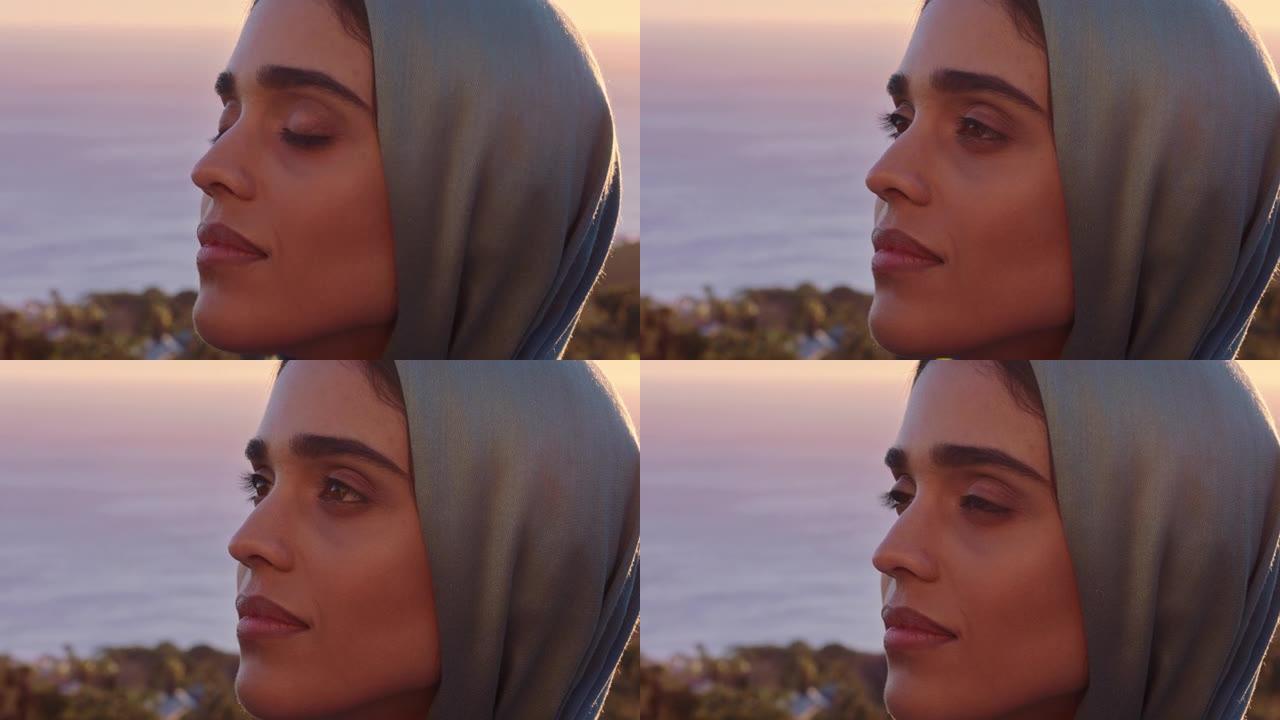 美丽的穆斯林妇女的特写肖像，看起来沉思，探索灵性，感觉和平，享受日落，戴着头巾