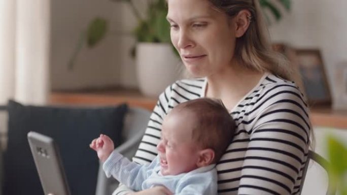 年轻的母亲使用智能手机安抚婴儿在家里哭泣妈妈抚慰不快乐的婴儿照顾孩子