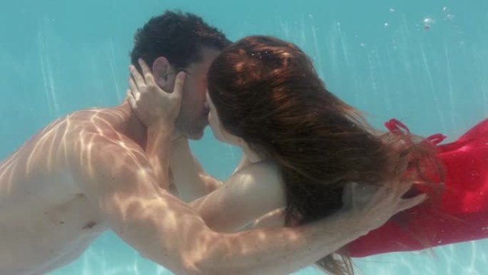浪漫的情侣在游泳池水下接吻诱人的女人与漂浮在水中的年轻人亲热，带着泡泡分享亲密的吻夏季浪漫4k