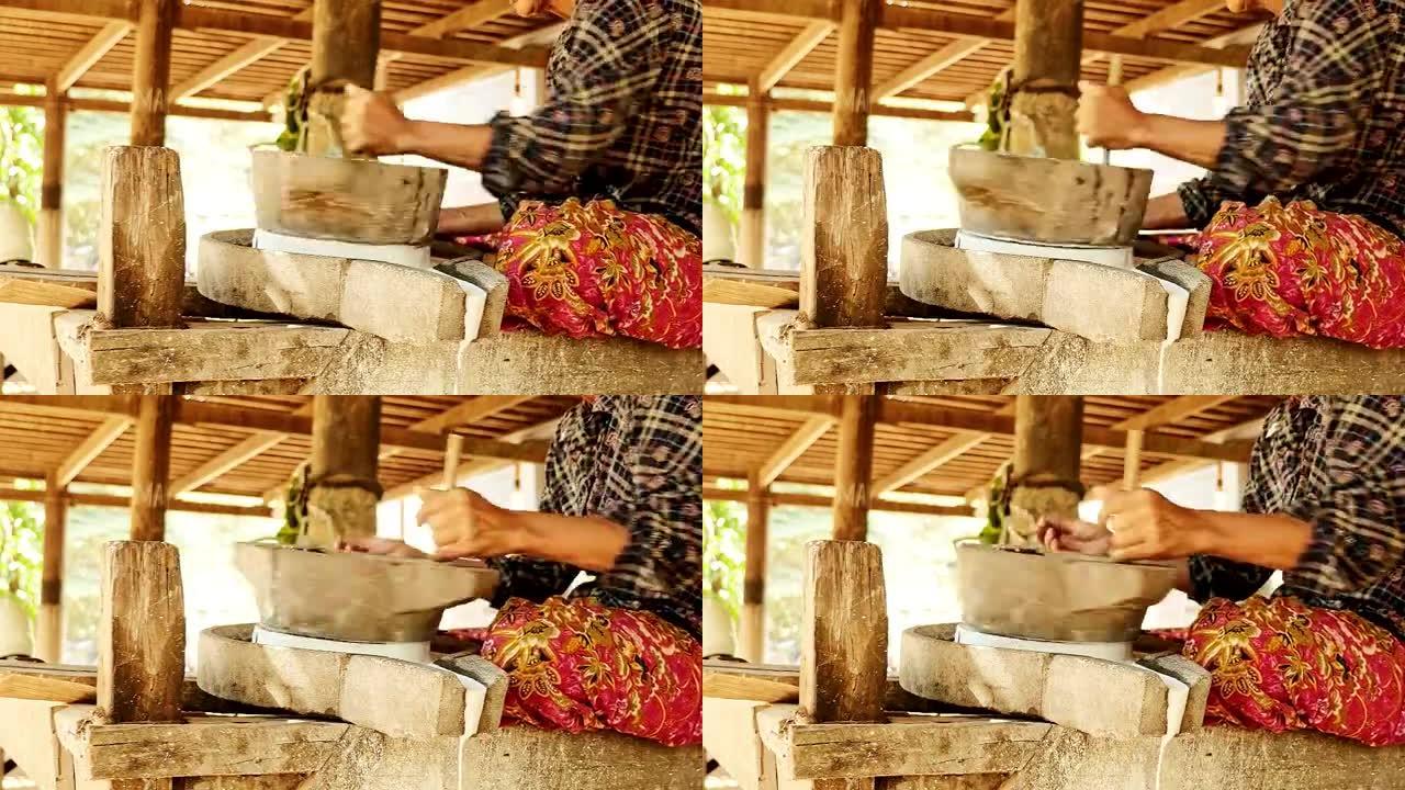 女人用手翻磨石磨湿米饭做浸泡米粉