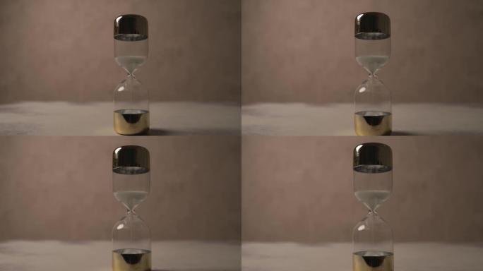 沙漏作为时间压力的项目视频，说明了时间在棕色背景前滴答作响的概念
