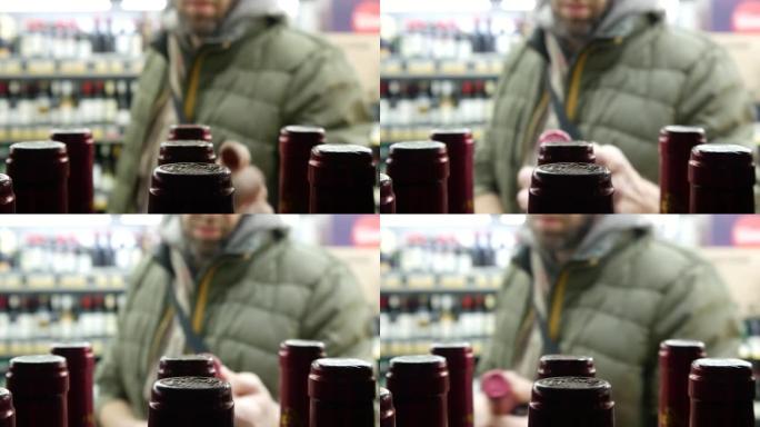 商店货架上的许多瓶红酒特写镜头，一个男人拿了一个