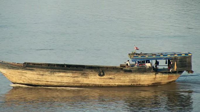 在河上行驶的大型木制挖泥驳船的平移镜头