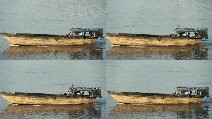 在河上行驶的大型木制挖泥驳船的平移镜头