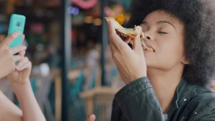 最好的朋友在餐厅吃披萨的女人用智能手机拍朋友吃饭的照片两个女人一起在社交媒体上分享周末的乐趣4k