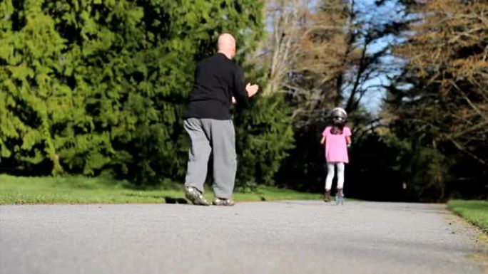 骄傲的父亲帮助女儿骑踏板车-与Helmut
